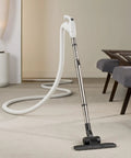 Universal 30 Ft Central Vacuum Kit With Suction Driven Turbo Nozzles shown cleaning carpet near a modern sofa
