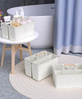 Portable Shower Caddy With Handle For Bathroom And Kitchen, Rust Resistant Durable Organizer With 3 Large Compartments, Easy To Clean, Milky White Finish, Space Saving Toiletries Storage, shown on a bathroom stool.