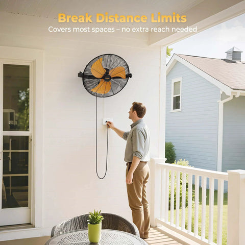 Man adjusting Heavy Duty 18 Inch Wall Mount Fan With Extended 6.6 Ft Cord, installed on a covered patio wall.