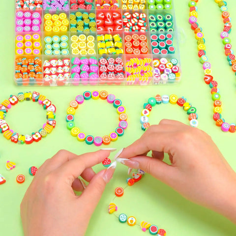 Colorful Fruit Polymer Clay Beads Bracelet Making Kit With Lemon Strawberry Avocado Watermelon Designs For DIY Jewelry Crafting Necklace And Bracelet Making Supplies, shown with beads and bracelets.