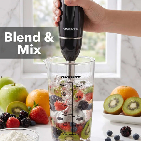 Badass Electric Hand Blender Set With Dual Speed Settings And 300 Watt Motor Includes Whisk Tool And BPA Free Chopper Cup For Knockout Smoothies Purees And Protein Shakes In Matte Black blending fruits in a measuring cup.