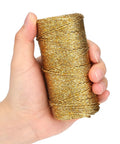 Hand holding Decorative Metallic Bakers String Gold Twine 110 Yards 1.5mm Inelastic Glitter String for DIY Crafting
