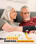 Couple relaxing on couch with black Carpal Tunnel Wrist Brace Go-To Night Sleep And Daywear All Day Comfort Cushioned Bead Wrist Support
