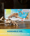 Bayraktar TB2 Combat Drone Wooden Model Kit With Movable Rudders, Wing Ailerons, Moving Camera And Underwing Missiles, Realistic 3D Puzzle For Adults, Durable Handcrafted Aircraft Building Toy For Collectors And Tinkerers. Wooden drone model on table, box behind