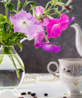 Petunia Cascading Seed Pod Kit For Indoor Hydroponic Garden, pink and purple petunias in vase, with tea cup and teapot