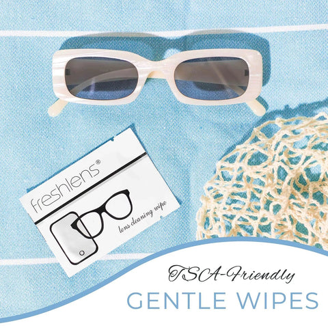 Freshends lens cleaning wipes; front view shows two items: white-frame sunglasses and wipe card on blue fabric