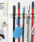 Mop And Broom Holder Wall Mount With Five Slots And Six Hooks, Heavy Duty Garage Organizer in off white, holding cleaning tools.