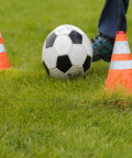 Two fluorescent orange traffic cones with reflective strips on grass, part of 4 Pack 27.6 Inch Collapsible Traffic Cones With Nighttime LED Lights