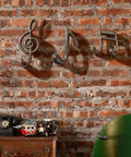 3 Piece Music Note Cast Iron Wall Hooks For Hanging Your Coats Hats And Totes Pretty Sweet Decorative Heavy Duty Coat Rack with a rustic brick wall.
