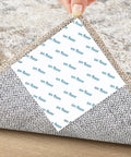 Anti Slip Rug Tape For Hardwood Floors 12 Pack Rug Grips White Rug Stickers showing under corner of a rug on wood floor