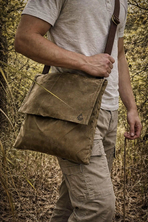 Person carrying XL Haversack Foraging Bag Waxed Canvas Bushcraft Messenger with Reinforced Straps in outdoor setting.