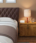Bedroom nightstand with lamp and books next to a tufted headboard, featuring 36 Piece Round Cabinet Knob Set With Screws For Kitchen Cabinets Drawers And Bedroom Furniture 1.2 Inch Diameter Hardware Knobs Easy Install Durable Finish No Fuss Update.