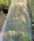 All Purpose Garden Hoop Kit With 5 Sets Of 7 Foot Fiberglass Hoops For Raised Beds Rust Proof Frame Garden Netting Greenhouse Kit Shade Cloth And Row Cover 25 Pieces proving a mini tunnel over plants.