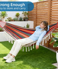 Woman relaxing in Brazilian Style Double Hammock With Fringe For Two People Outdoor Patio Or Indoors Cozy Breathable Fabric