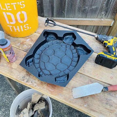 DIY Concrete Stepping Stones Mold Kit With Turtle Statue Texture For Garden Pathway on a workbench with tools