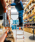 30 Inch Tilting Pedestal Fan in warehouse with worker on ladder, 3 speed high velocity, heavy duty motor for industrial use