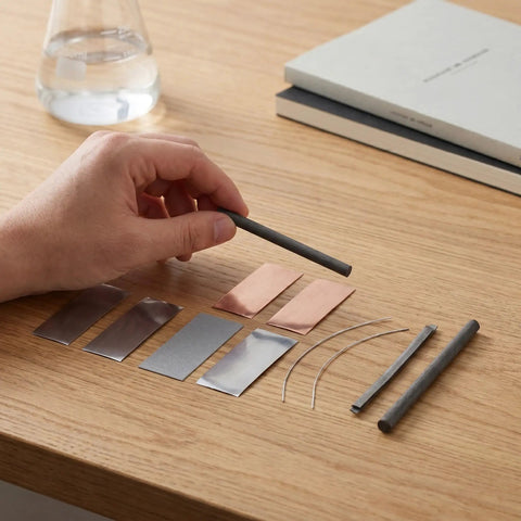 Person holding graphite rod from Metal Electrodes Kit For Basic Electricity Science Demos With Zinc Sheets Copper Plates Iron Anode Sheet