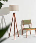 Eden Tripod Floor Lamp Dimmable LED With Solid Wood Legs next to green chair, modern rustic decor, mid-century inspired design.