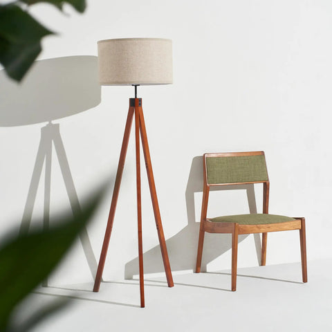 Eden Tripod Floor Lamp Dimmable LED With Solid Wood Legs next to green chair, modern rustic decor, mid-century inspired design.