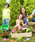 Family gardening with Eight Pack Self Watering Spikes For Plants With 60ml Bird Shape Automatic Watering Globes in a garden.