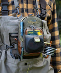 Person wearing Vertical Fly Fishing Chest Pack with Zippered Main Compartment and Interior Pocket, low profile in tidal blue on chest.
