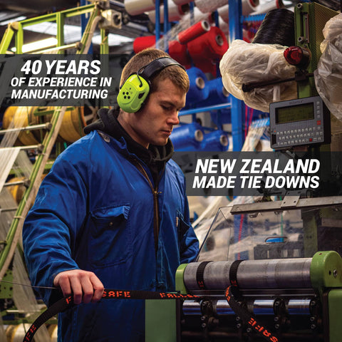 Worker inspecting rear transom boat trailer straps ratchet tie downs in a New Zealand manufacturing facility