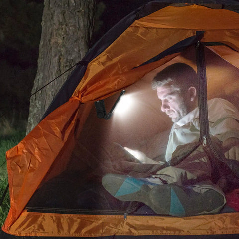 Man reading in tent using 4 Pack LED Work Lights With COB Beams Rechargeable Flashlights Magnetic Base Hanging Hook