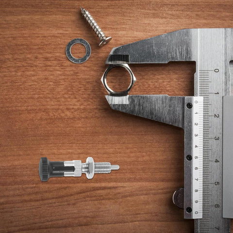 Heavy Duty Stainless Steel Spring Plunger Pin With Knurled Grip And Quick Release Pull Ring on a wood surface with tools.