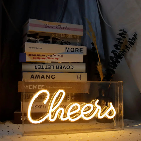 Plug And Play USB LED Lightbox Cheers Sign With 3D Neon Glow for Bar and Home Decor in warm light setting with books and leaves