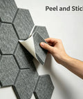 Person applying 12 Pack Hexagon Acoustic Foam Panels Self Adhesive Sound Dampening Tiles to wall for soundproofing.