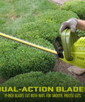Multi Angle Telescoping Electric Hedge Trimmer with 19-inch dual-action blades trimming bushes for precise cuts.