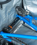 Dummy Hub Axle Chain Keeper for 12mm Thru Axle and QR Frames shown protecting blue bike's rear triangle during transit