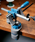 3 in 1 Multi Vise Attachment for Dremel Rotary Tool, mounted on workbench, holding metal pipe with 360-degree rotation, in use