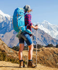 Hiker with a blue backpack overlooking mountains, utilizing Badass 3 Inch Aluminum Carabiner Clips for gear organization.