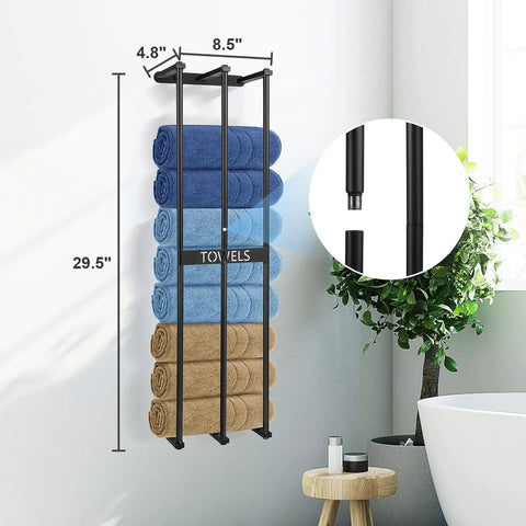 Towel rack mounted on wall with blue and brown folded towels, black metal design, dimensions shown, next to plant and bathtub.