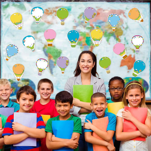 Teacher and students holding notebooks with a map and Hot Air Balloon Sticky Notes Bulk Pack in 9 styles displayed on the board.
