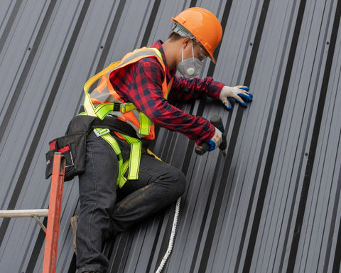 BCP640 1/4 inch stainless steel EPDM bonded washers; contractor on a sloped metal roof in safety gear.