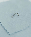 Implant Grade Titanium Nose Stud 20G with cubic zirconia sparkle on soft fabric surface, perfect for sensitive skin.