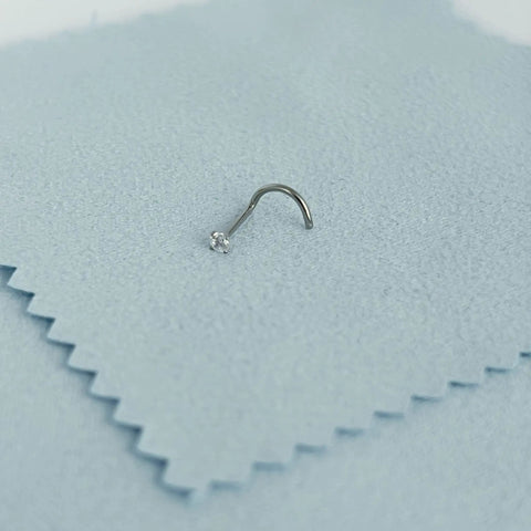 Implant Grade Titanium Nose Stud 20G with cubic zirconia sparkle on soft fabric surface, perfect for sensitive skin.