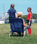 Person sitting on Big Boy 4-Position Folding Backpack Chair With 13 Inch High Seat For Beach Or Camp during a soccer game