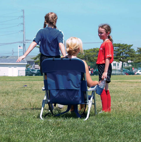 Person sitting on Big Boy 4-Position Folding Backpack Chair With 13 Inch High Seat For Beach Or Camp during a soccer game