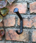 Rustic Cast Iron Wall Mount Coat Hooks Set Of 4 For Entryway, Farmhouse Style Towel Hanger on a brick wall
