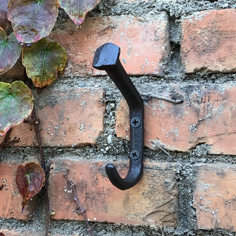Rustic Cast Iron Wall Mount Coat Hooks Set Of 4 For Entryway, Farmhouse Style Towel Hanger on a brick wall