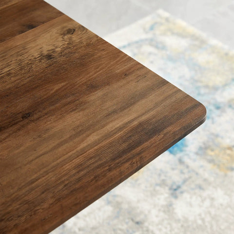 Close-up of the walnut finish wood top of the Modern Wood Top Dining Table With Sturdy Black Metal Base.