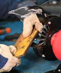 User operating a Six Inch Wide Face Bench Grinder Wire Wheel on a rusty metal piece, demonstrating its effective cleaning capabilities.