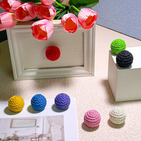 Colorful jute rope knobs displayed on surfaces, showcasing the 6 Pack Jute Rope Cabinet Knobs Set 1.26 Inch Round Wood Knobs.