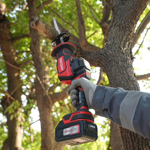 Person using Beast 20V Max Brushless Cordless Recip Saw With LED Light 3100 RPM 5Ah Battery And Fast Charger outdoors on tree limb.