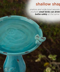 Shallow bowl of 25 Inch Tall Outdoor Ceramic Antique Pedestal Birdbath With Turquoise Finish And Two Playful Bird Figurines