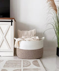 XXL Cotton Rope Blanket Basket With Handles For Living Room Storage 21.7 Inches Square And 13.8 Inches Tall Handwoven next to cabinet with pillow and blanket