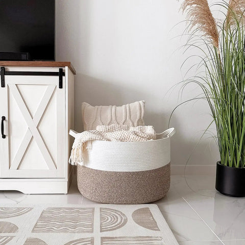 XXL Cotton Rope Blanket Basket With Handles For Living Room Storage 21.7 Inches Square And 13.8 Inches Tall Handwoven next to cabinet with pillow and blanket